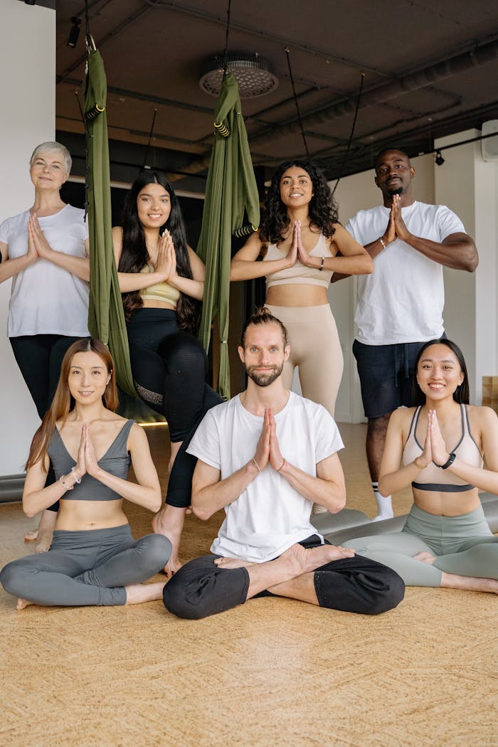A multicultural group practicing yoga poses in an indoor studio setting, embracing health and mindfulness.